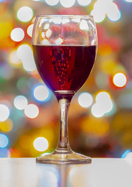 Una copa de vino con luces de Navidad en el fondo. Vista vertical — Foto de Stock