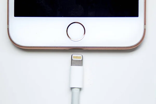 Primo piano di un iPhone Plus e un cavo Lightning to USB. Apple sta uccidendo Lightning connettore su iPhone entro il 2021. Illustrativo — Foto Stock