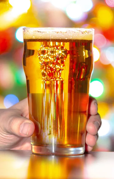 Pivní půllitr a sklenice s vánočními světly na pozadí — Stock fotografie