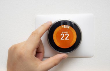 Smart Thermostat with a person warming up the room temperature with a soft shadow clipart