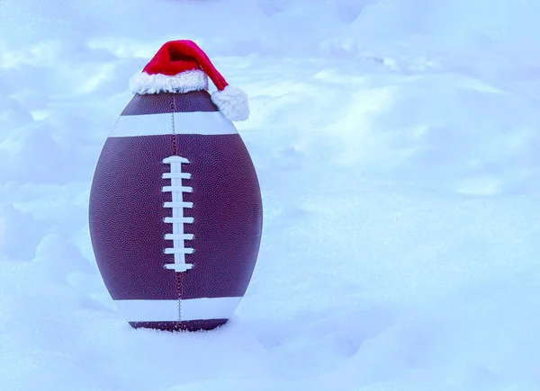 雪の上にサンタクロースの帽子をかぶっているアメリカのサッカー — ストック写真