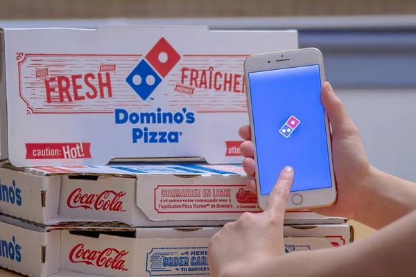 Calgary, Alberta. Kanada 26 Aralık 2019. Bir iPhone Artı 'da Dominos Pizza uygulamasını kullanan birinin fotoğrafını çek. Dominos Pizza Dominos satış baskılarına rağmen büyüme planına sadık kalıyor. Çizimsel