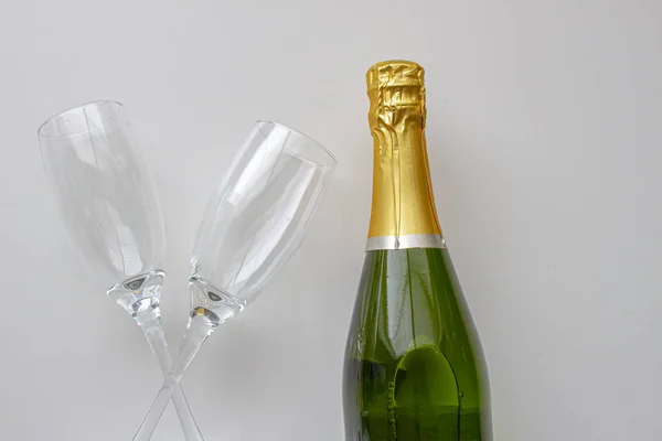 Neotevřená láhev šampaňského s poháry na bílém pozadí — Stock fotografie