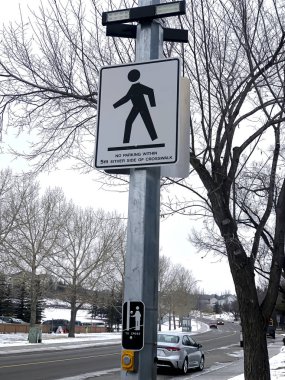 Caddede çapraz ışıklandırmalı yaya geçidi tabelası.