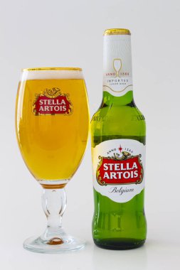 Yanında bira bardağı olan bir şişe Stella Artois birası.