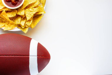 Organik cips ve beyaz arka planda hafif salsa soslu bir Amerikan futbolu.
