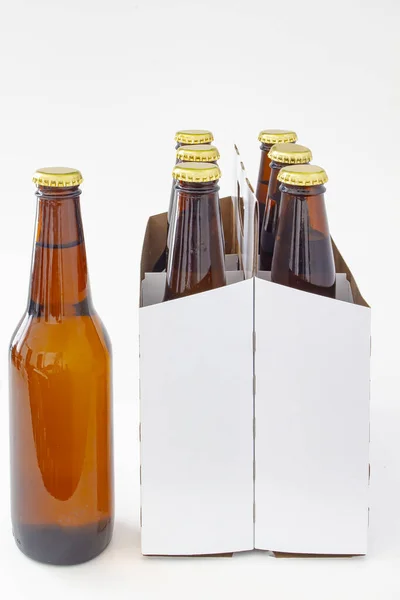 A person holding a beer with a six pack of a brown beer bottles isolated on white background — 스톡 사진