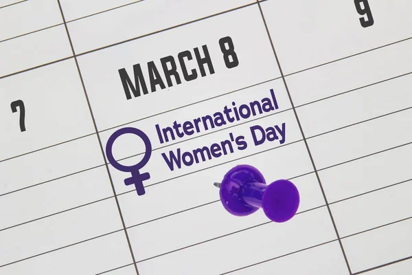 A close up to a Calendar on March 8 with the text: International Women\'s Day with a purple pin