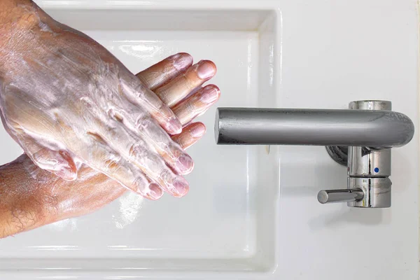 在洗脸盆上用肥皂洗手的人的头像 — 图库照片