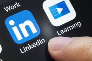 Calgary, Alberta. Kanada mı? 11 Nisan 2020. LinkedIn ve Öğrenme uygulamasını siyah arkaplanda açmak üzere olan bir kişi.