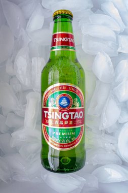 Calgary, Alberta, Kanada. 17 Nisan 2020. Buz yatağında bir Tsingtao bira şişesi..