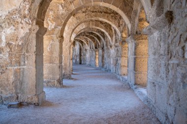 Türkiye 'nin Antalya kentindeki Roma Amfiteatrı Aspendos' un kemerli koridorlarından birinin güzel perspektifi. Önplanda ışık efekti olan güzel, dokulu duvarlar..