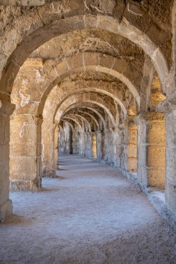 Türkiye 'nin Antalya kentindeki Roma Amfiteatrı Aspendos' un kemerli koridorlarından birinin güzel perspektifi. Önplanda ışık efekti olan güzel, dokulu duvarlar..