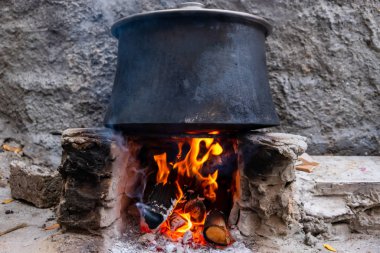 Ateşin üstünde tencerede yemek pişirmek. Kamp kavramı