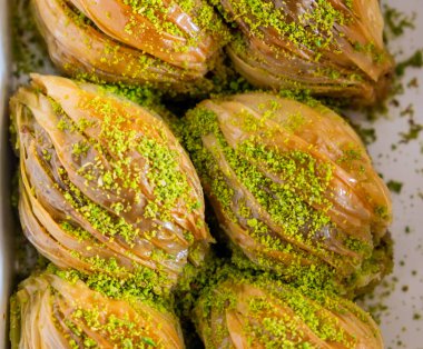Yeşil Pistachio Pudrası ve Tereyağı Kremalı Türk Midye Baklava (Midye Şeklinde Baklava). 