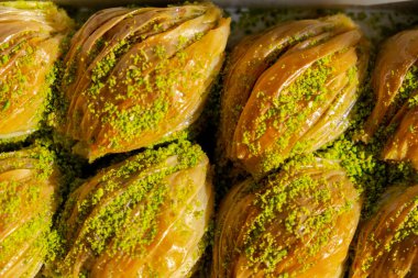 Yeşil Pistachio Pudrası ve Tereyağı Kremalı Türk Midye Baklava (Midye Şeklinde Baklava). 