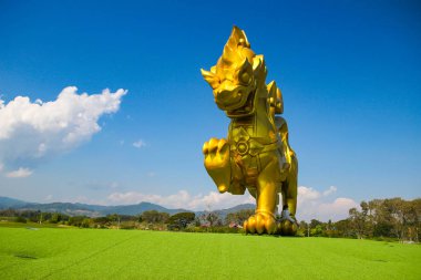 Chiangrai, Tayland. - 21 Ocak 2019 'da Singha Parkı Chiangrai Tayland' daki mavi gökyüzü arka planında bulunan altın aslan heykeli..