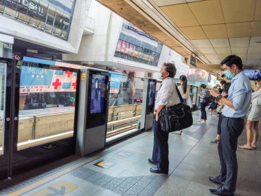Bangkok, Tayland - Şubat 2020: Bangkok Tayland 'daki virüs salgını sırasında Coronavirus, Covid 19 virüsünü korumak için koruyucu maske takıyorlar. Metroda ya da BTS gökyüzü treninde maske takanlar.