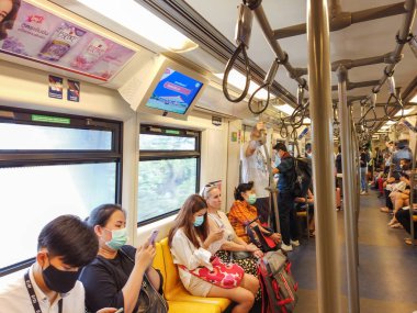 Bangkok, Tayland - Şubat 2020: Bangkok Tayland 'daki virüs salgını sırasında Coronavirus, Covid 19 virüsünü korumak için koruyucu maske takıyorlar. Metroda ya da BTS gökyüzü treninde maske takanlar.