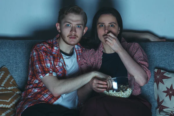 young couple watching thriller movie