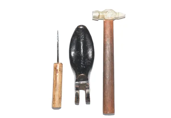 old shoemaker tools, hammer, awl isolated on white background