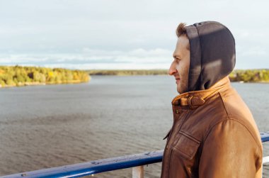 A happy man on board the ferry ship around Scandinavia in autumn clipart
