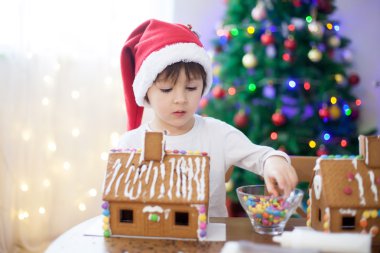 Sevimli küçük çocuk, zencefilli kurabiye ev için Noel'e hazırlanmak