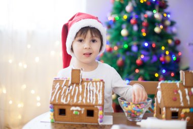 Sevimli küçük çocuk, zencefilli kurabiye ev için Noel'e hazırlanmak