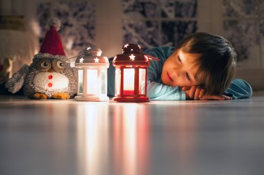 Mum seyir yere uzanmış güzel bir çocuk,
