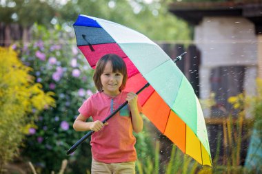 S altında renkli şemsiye ile oynayan sevimli sevimli çocuk, çocuk,