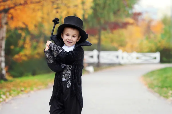 Garoto bonito no parque, vestindo trajes de mágico para o Halloween — Fotografia de Stock