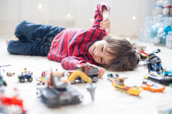Kisgyerek játszik sok színes műanyag játékok beltéri — Stock Fotó