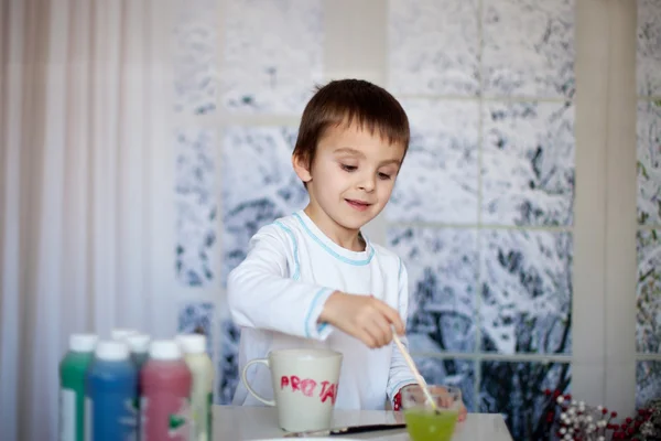 Lindo niño preescolar, dibujo en taza para su padre —  Fotos de Stock