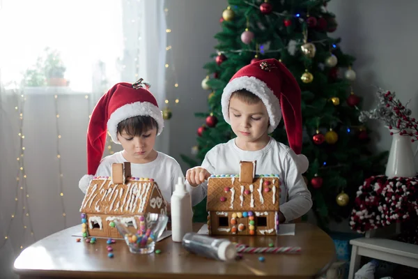 Två söta pojkar, bröder, att göra pepparkakor cookies house, deco — Stockfoto