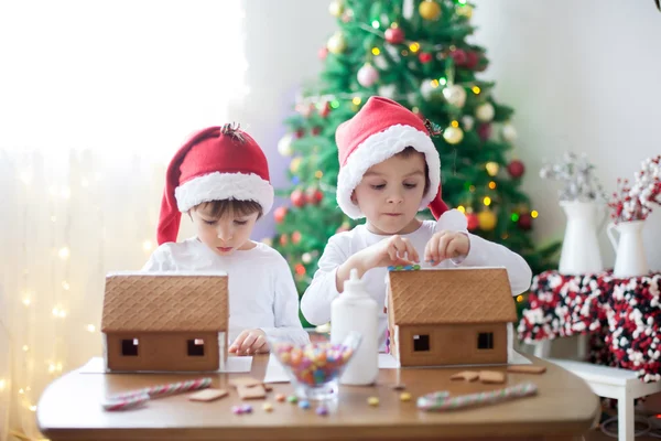 Two sweet boys, brothers, making gingerbread cookies house — Stock Photo, Image