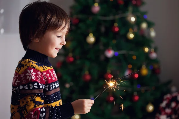 Beautiful Little child holding burning sparkler on New Year 's Ev — стоковое фото