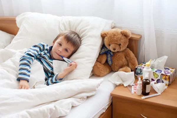 Sjukt barn pojke i sängen med feber, vila — Stockfoto