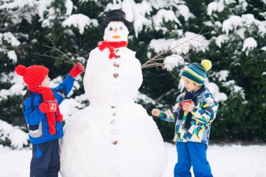 Mutlu güzel çocuklar, kardeşler, Bina kardan adam bahçe içinde bir