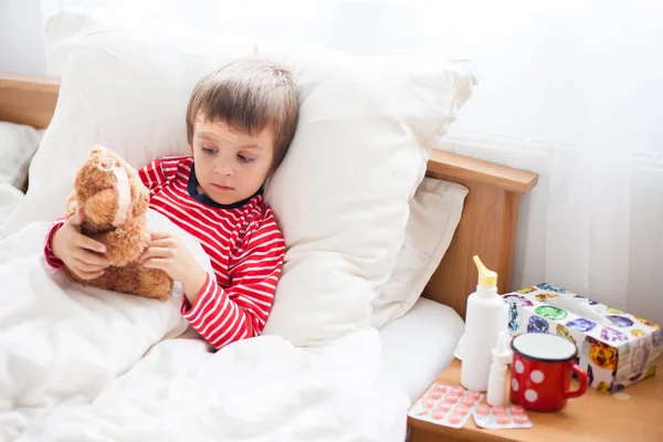 Niño enfermo acostado en la cama con fiebre, descansando — Foto de Stock