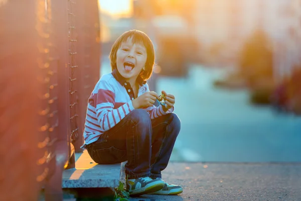 Lindo niño preescolar, jugando con juguetes en la calle en su — Foto de Stock