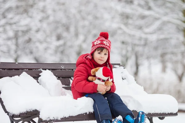 Ted tutan karlı bir parkta oynayan sevimli küçük çocuk, çocuk, — Stok fotoğraf