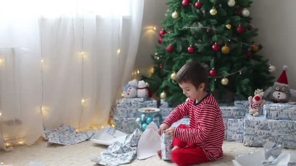 Χαριτωμένα αγόρια, παιδιά προσχολικής ηλικίας, το άνοιγμα παρουσιάζει την ημέρα των Χριστουγέννων — Αρχείο Βίντεο