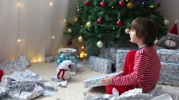 かわいい男の子、就学前の子供を開くをクリスマスの日にプレゼントします。 — ストック動画