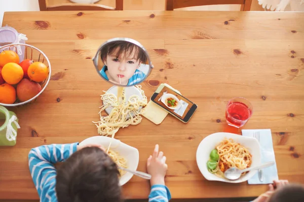 Två söta barn, pojke bröder, att ha för lunch spaghetti på — Stockfoto