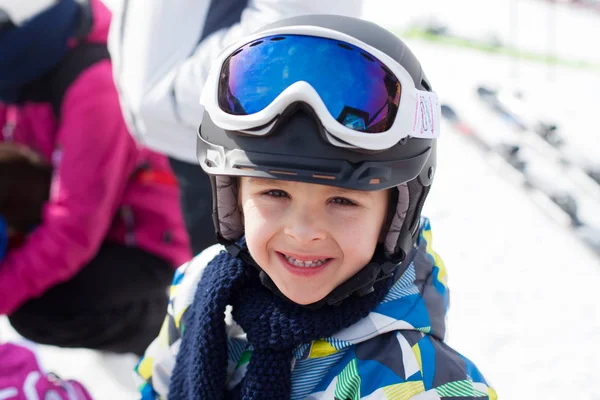 Bonito menino esquiador feliz em uma estância de esqui de inverno — Fotografia de Stock