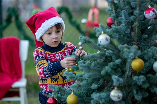 Lindo niño pequeño, árbol de Navidad de decoración, al aire libre —  Fotos de Stock