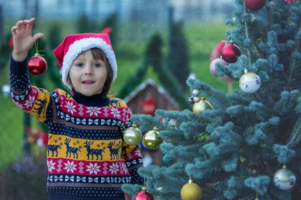 Lindo niño pequeño, árbol de Navidad de decoración, al aire libre —  Fotos de Stock