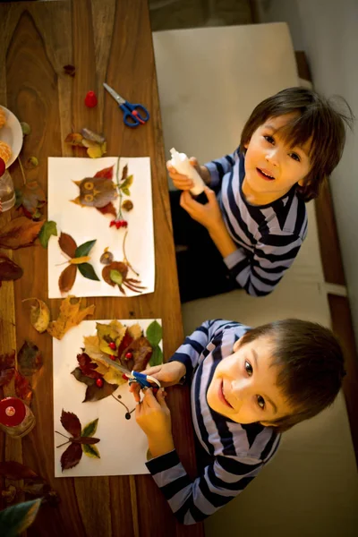 Tatlı çocuk, çocuk sanat tutkal kullanarak yaprakları uygulayarak, bir — Stok fotoğraf