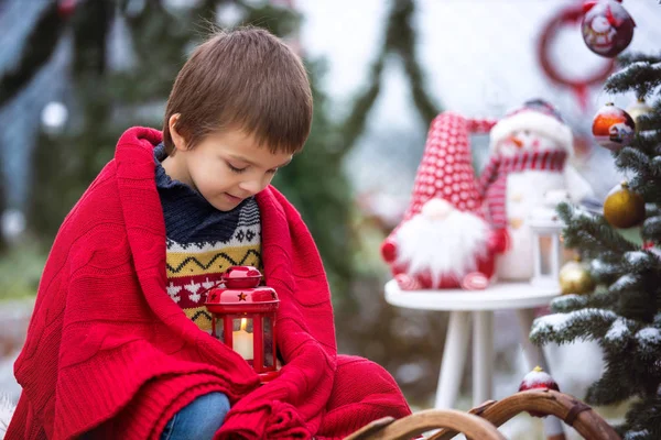 Niedliches kleines Kind, Junge, auf einem Schlitten neben einem Weihnachtsbaum sitzend — Stockfoto