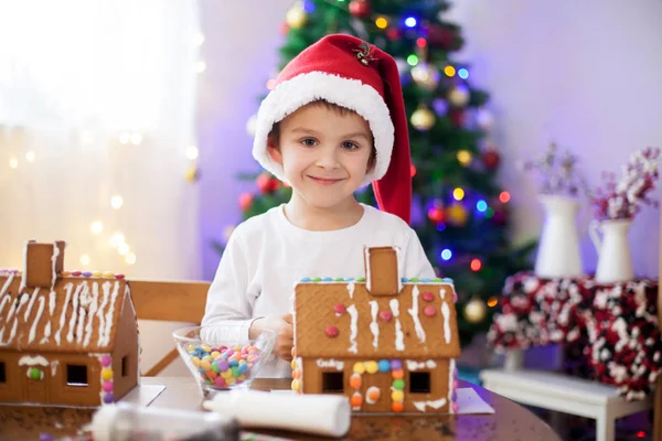 Söt liten pojke, att göra pepparkakshus kakor till jul — Stockfoto